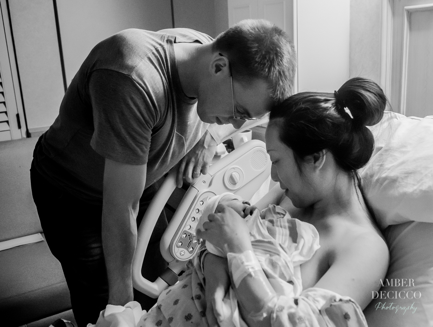 Mom and dad admiring their baby | Birth Photography ©Amber DeCicco Photography