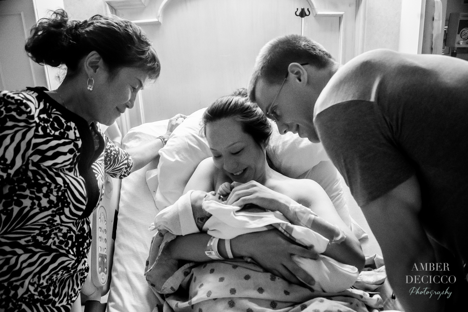 Everyone gathers around to see the babies sweet face | Birth Photography ©Amber DeCicco Photography