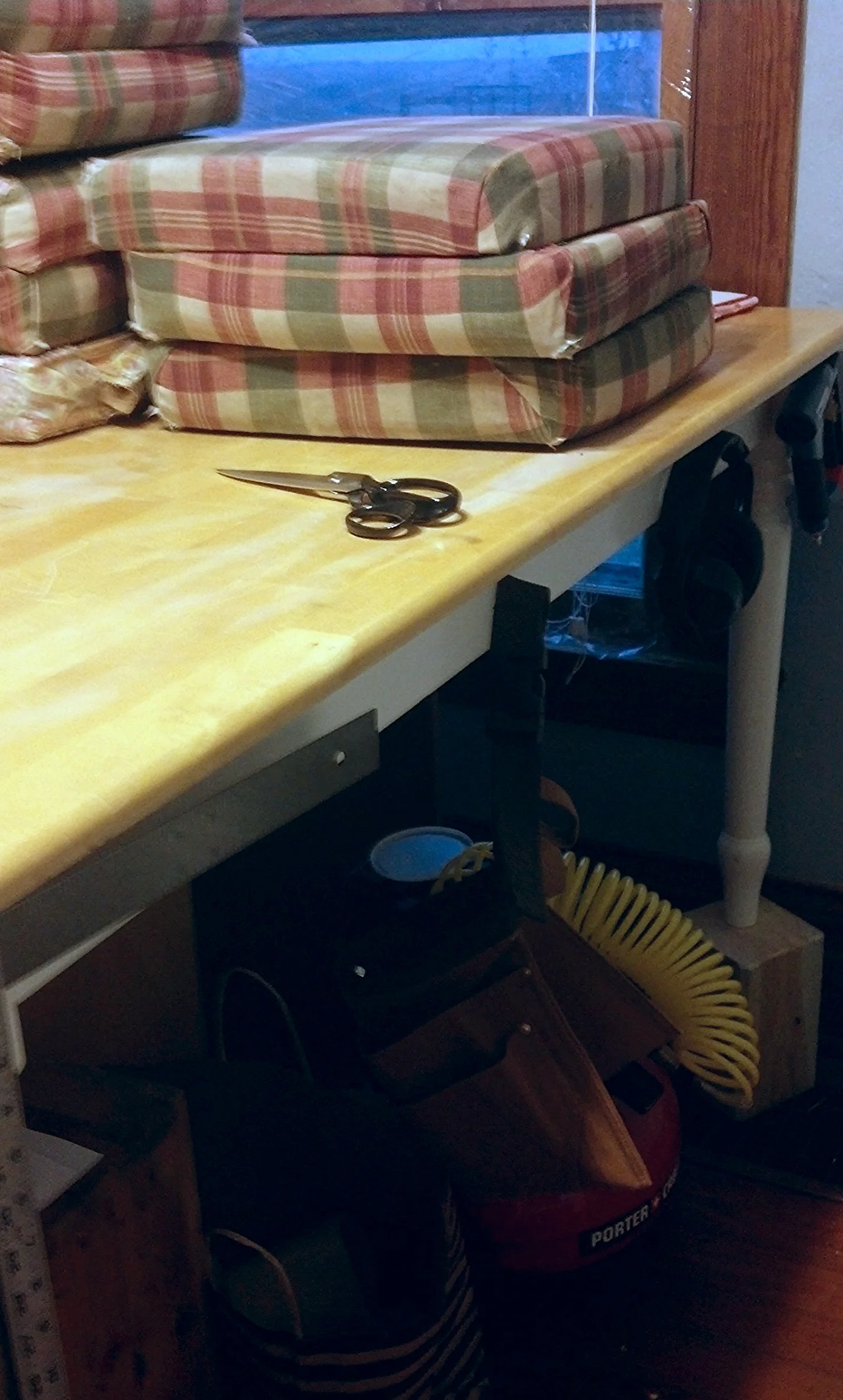 I put a cast-off dining table to work by raising it up on blocks to create a more comfortable height, as well as to increase storage space underneath. A few nails in the sides hold frequently needed supplies. 