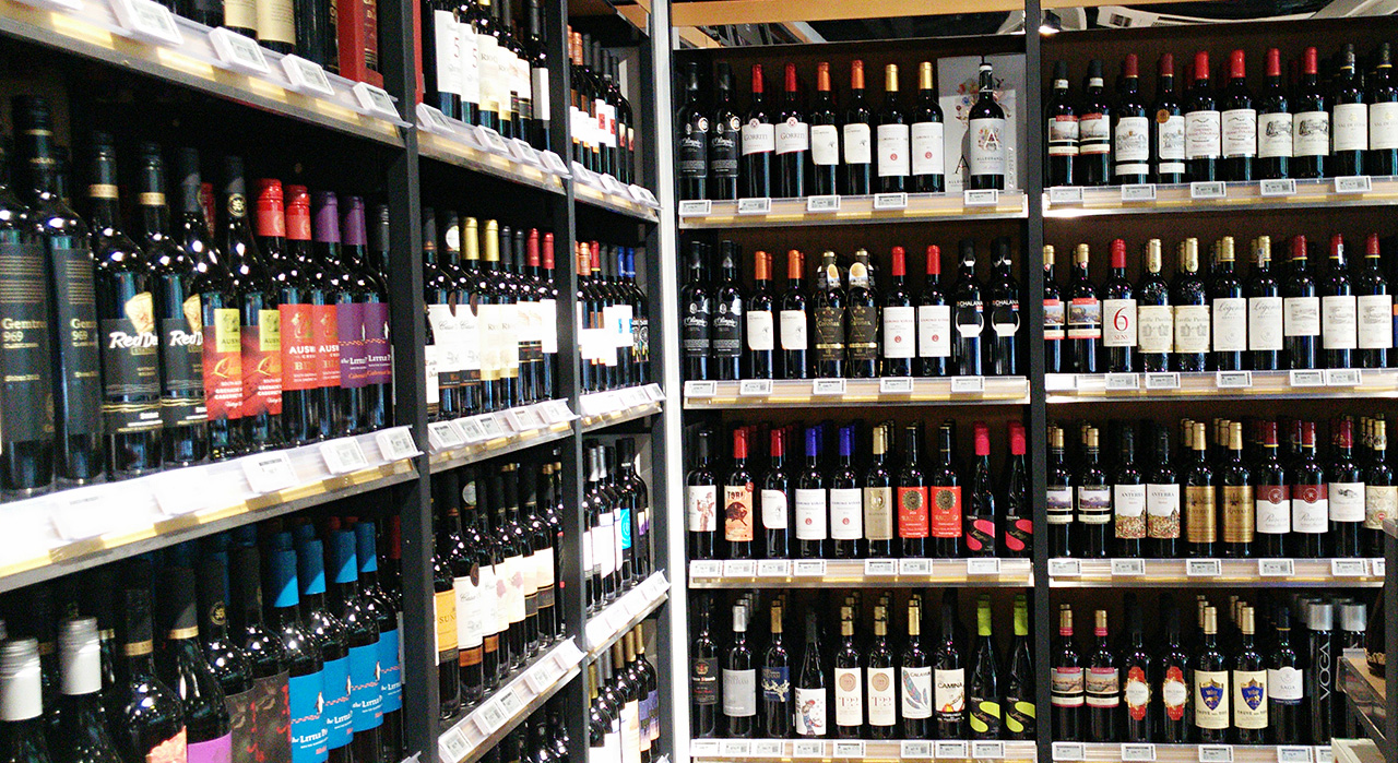 Digital price tags on shelf railings in a bottle shop