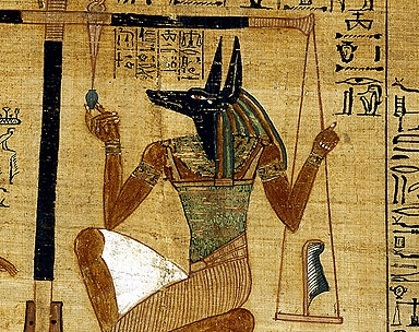Anubis, weighing a heart against a feather in the Egyptian Book of the Dead.