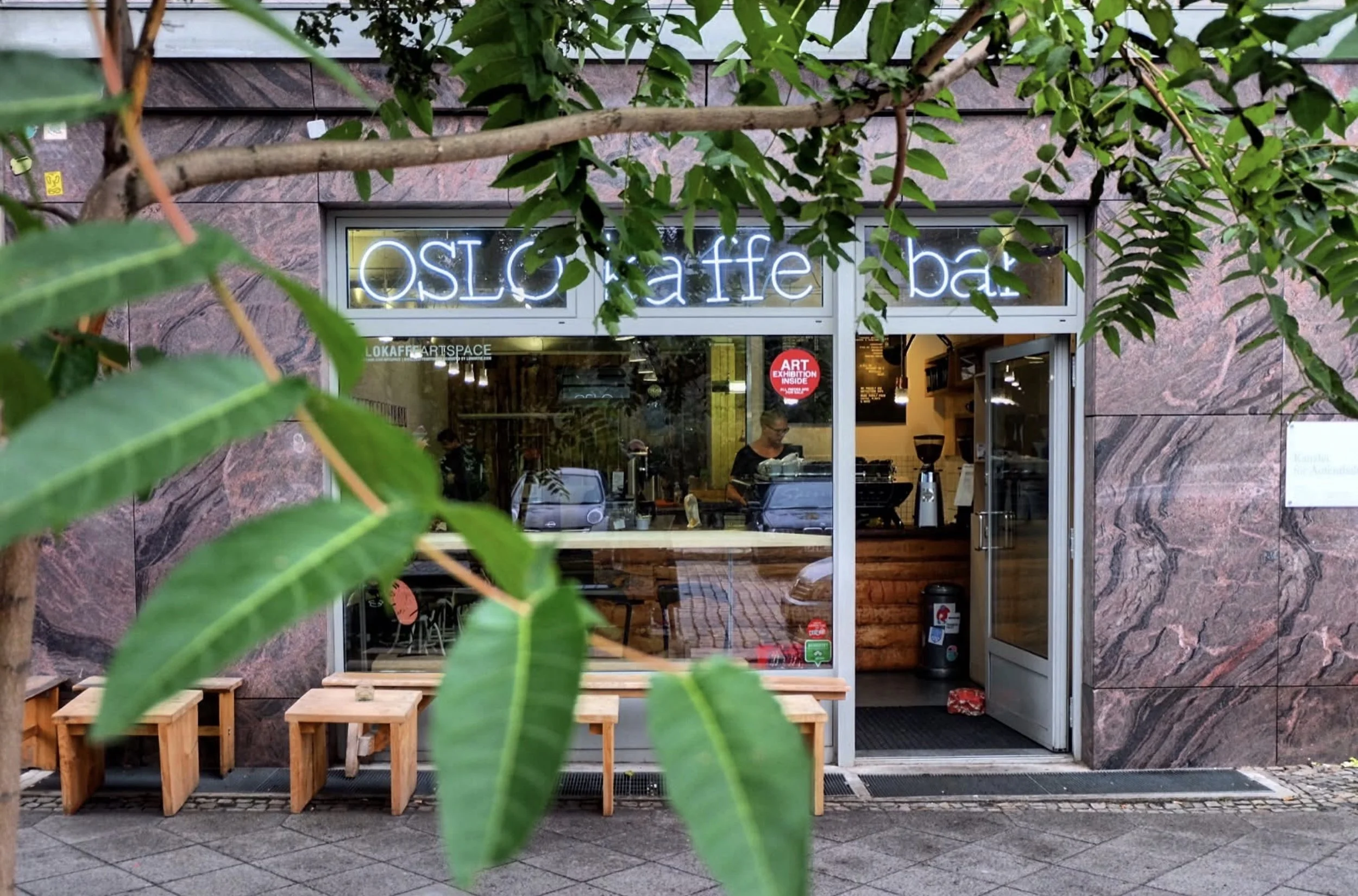 Entrance of Oslo Kaffebar in Berlin Mitte with open door in and visible interior in the summer