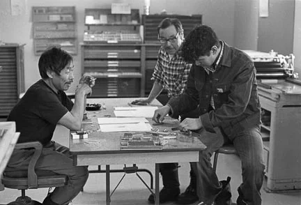 In this picture you can see the Vandercook 4T and the type drawers along the back wall. Left to right: Aggeak Petaulassie, Simionie Koopapik and Pitsiulak Pinguartuk (identified by Qiatsuq Niviaqsie). Photo: Tessa MacIntosh