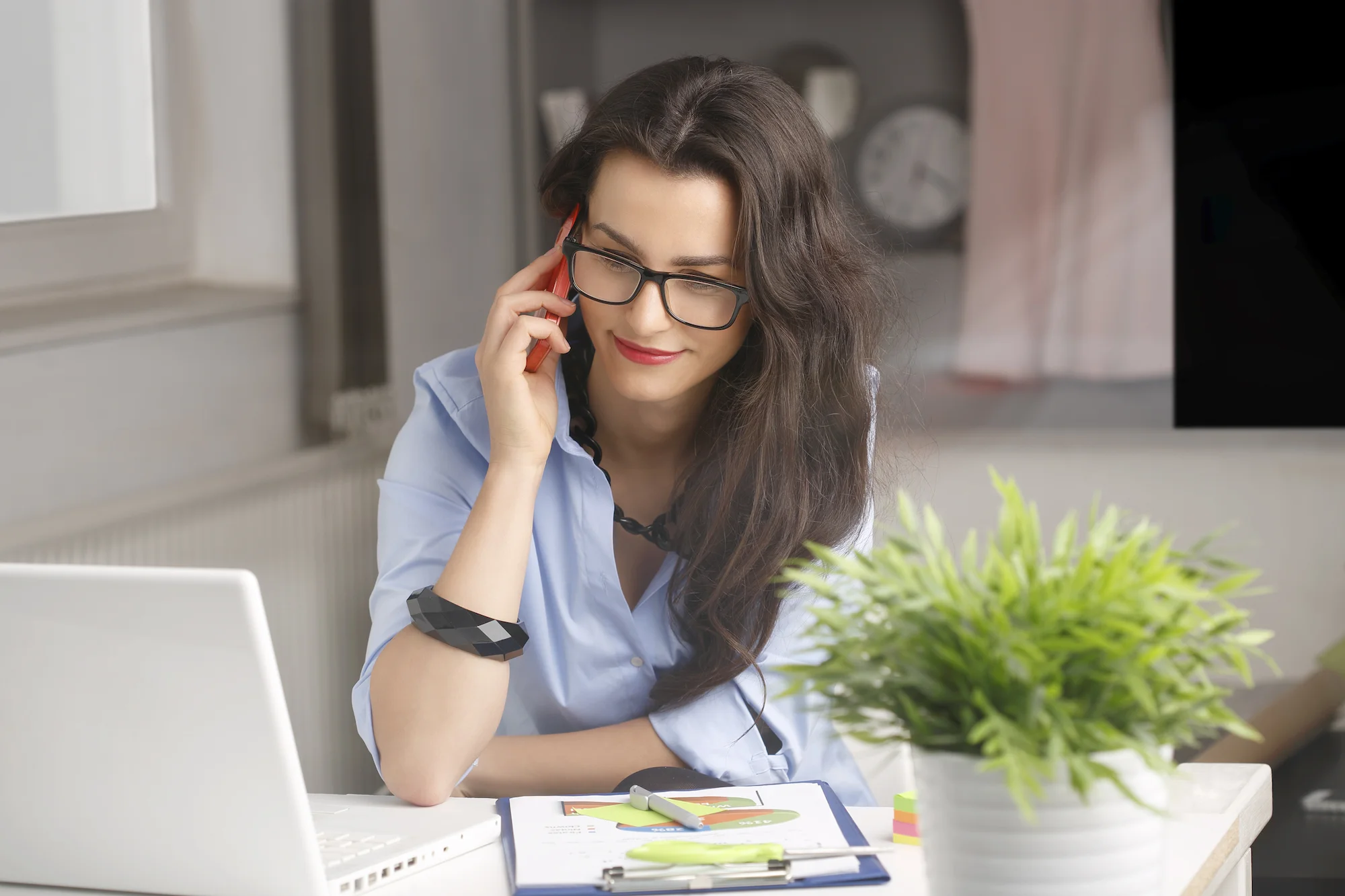 Business-woman-on-her-phone-at-desk.jpeg