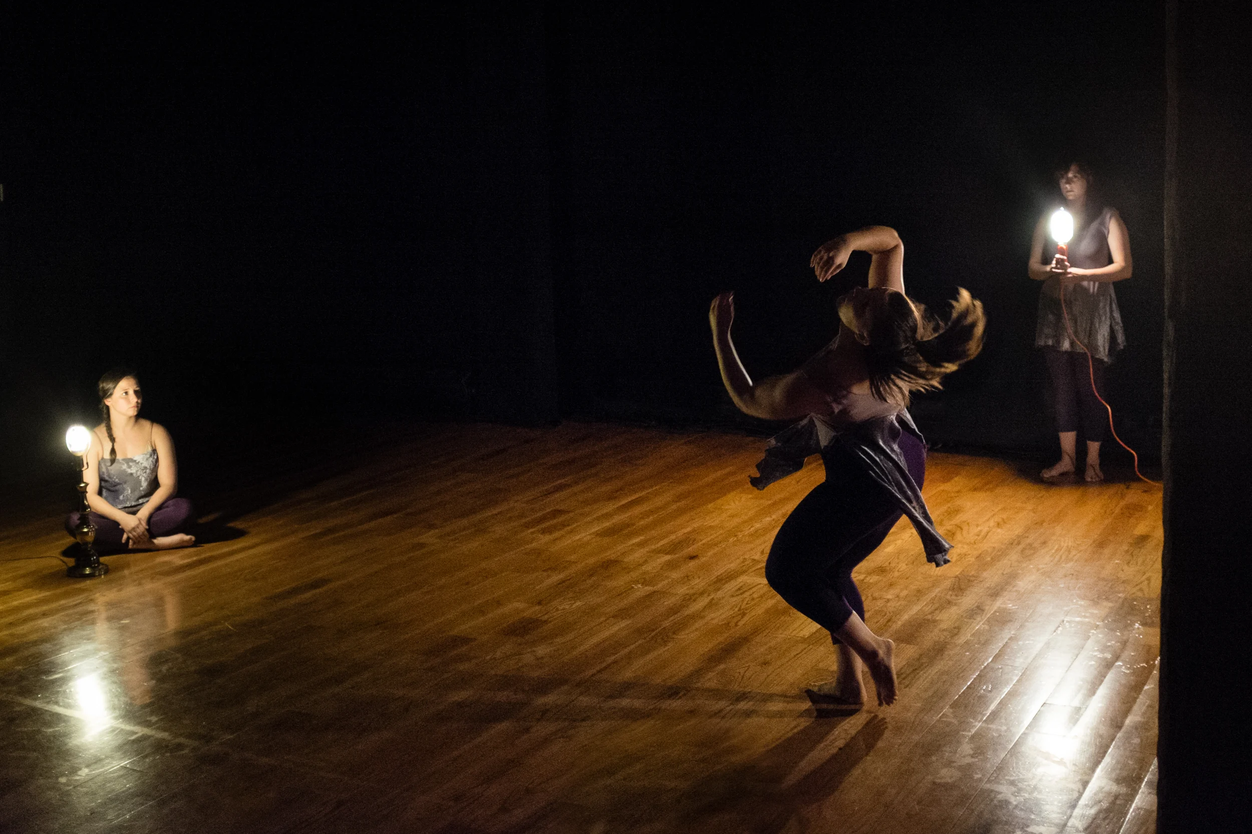 Megan performing her solo, with Rebecca and Michelle lighting and observing.