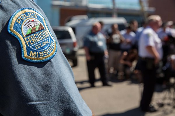 Ferguson, Mo., police officers at a news conference in August. A Justice Department report will force Ferguson officials to either negotiate a settlement with the department or face being sued by it on charges of violating the Constitution. Credit: Whitney Curtis for The New York Times