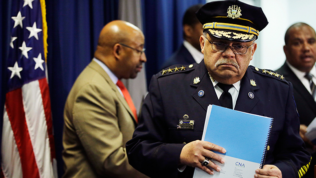 Philadelphia Police Commissioner Charles Ramsey holds the DOJ report during a news conference on Monday. Matt Rourke/AP