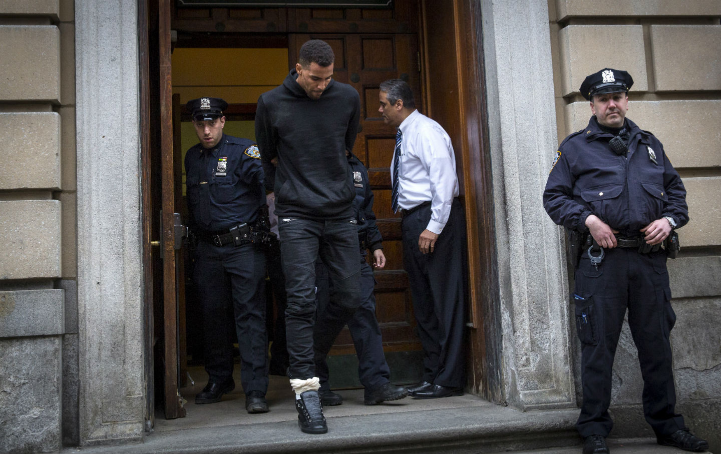 NBA player Thabo Sefolosha of the Atlanta Hawks is escorted out of the NYPD’s 10th Precinct with a fractured fibula on April 8, 2015. (Reuters/Andrew Kelly)