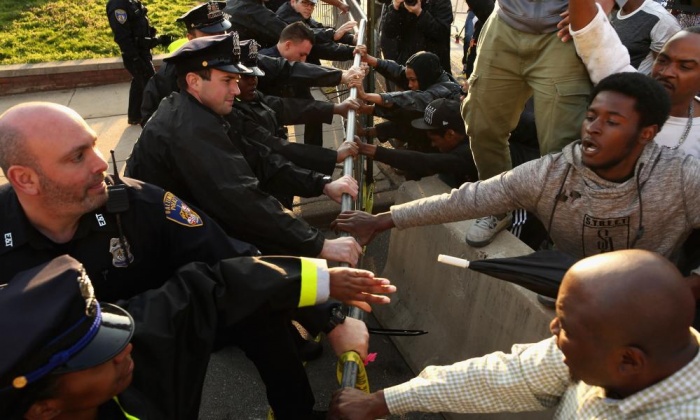 Demonstrators and police officers wrestle over a metal barricade during the protest on Wednesday in West Baltimore. Photograph: Chip Somodevilla/Getty Images