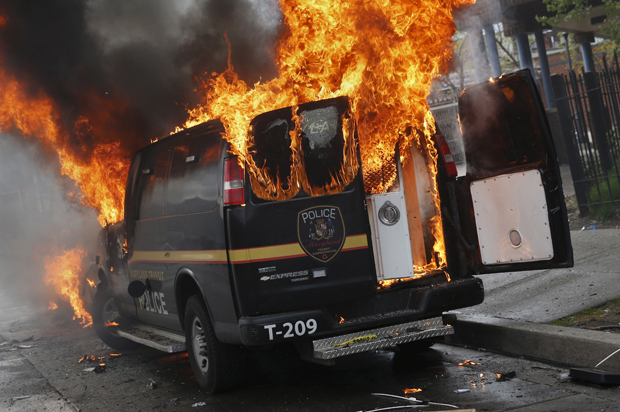A Baltimore Metropolitan Police transport vehicle burns during clashes in Baltimore, Maryland April 27, 2015. (Credit: Reuters/Shannon Stapleton)