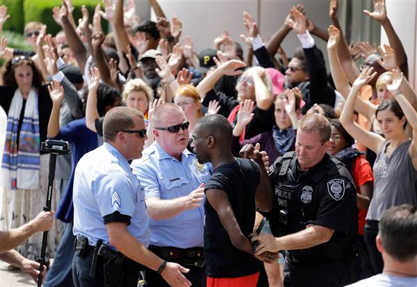 Activist DeRay McKesson is arrested by St. Louis and Federal Protective Service police outside the Thomas F. Eagleton Federal Courthouse on Monday, August 10, 2015. Several protesters were arrested. Jeff Roberson / AP
