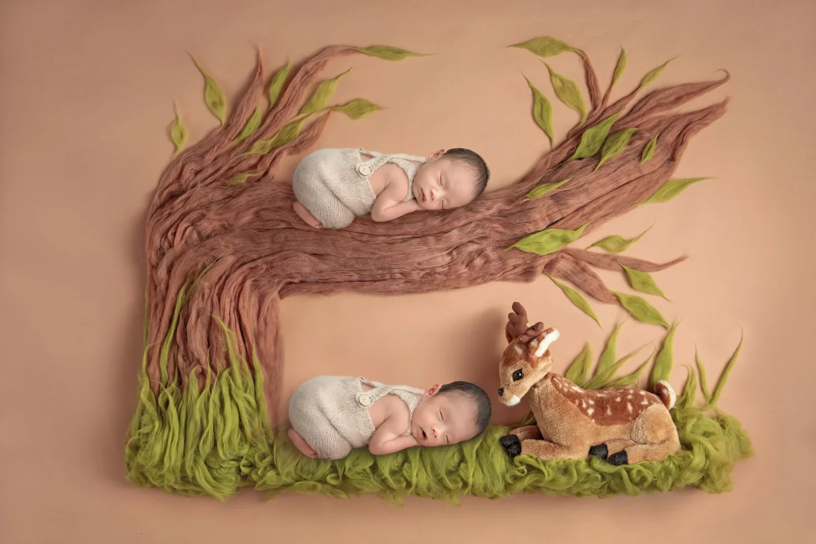 Sleeping twin newborns on a tree branch and grass beside a deer in a digital woodland composition