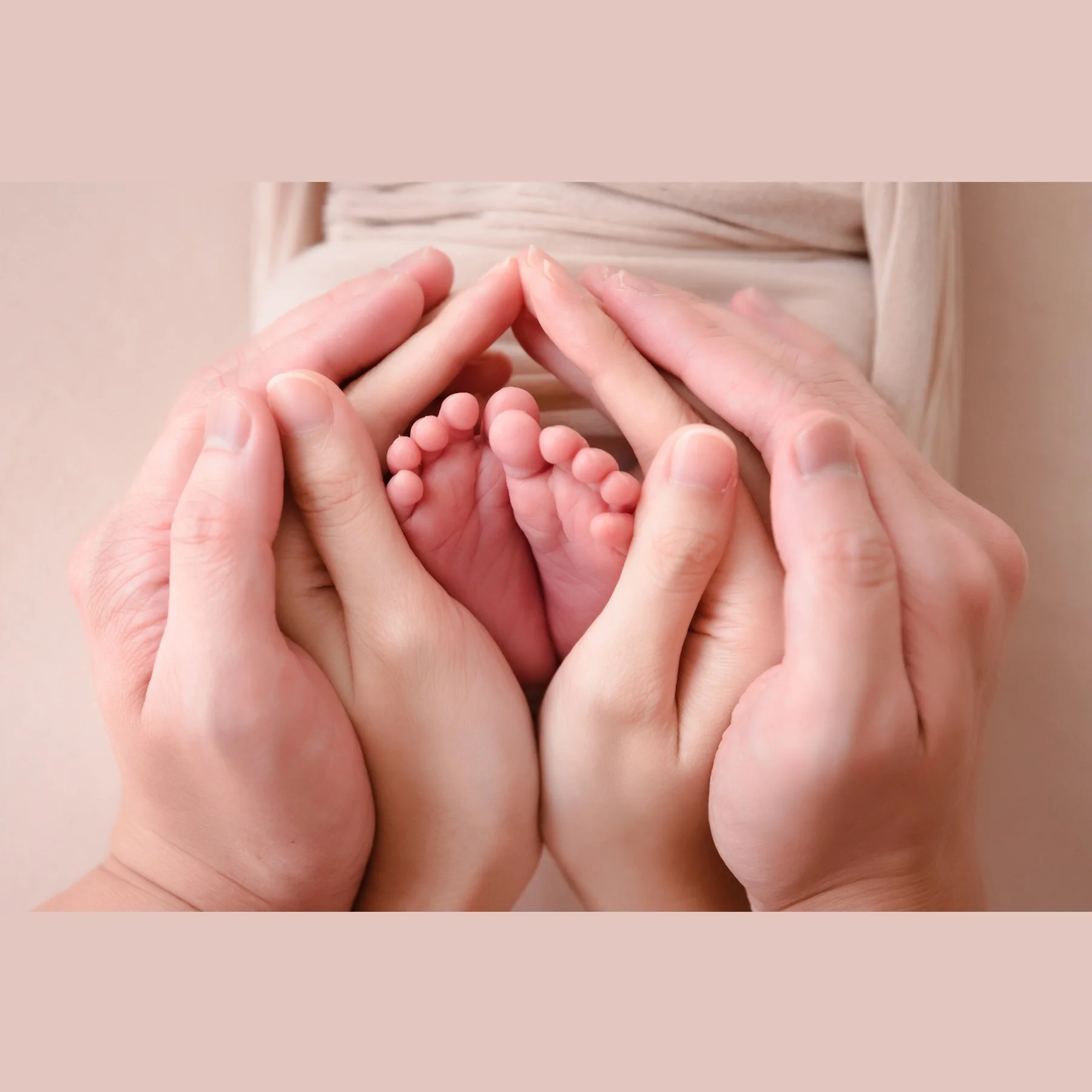 Close-up of tiny newborn feet gently cupped in two pairs of adult hands against soft cream fabric