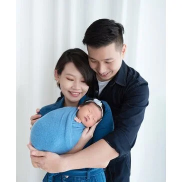 Parents smiling down at their newborn wrapped in blue