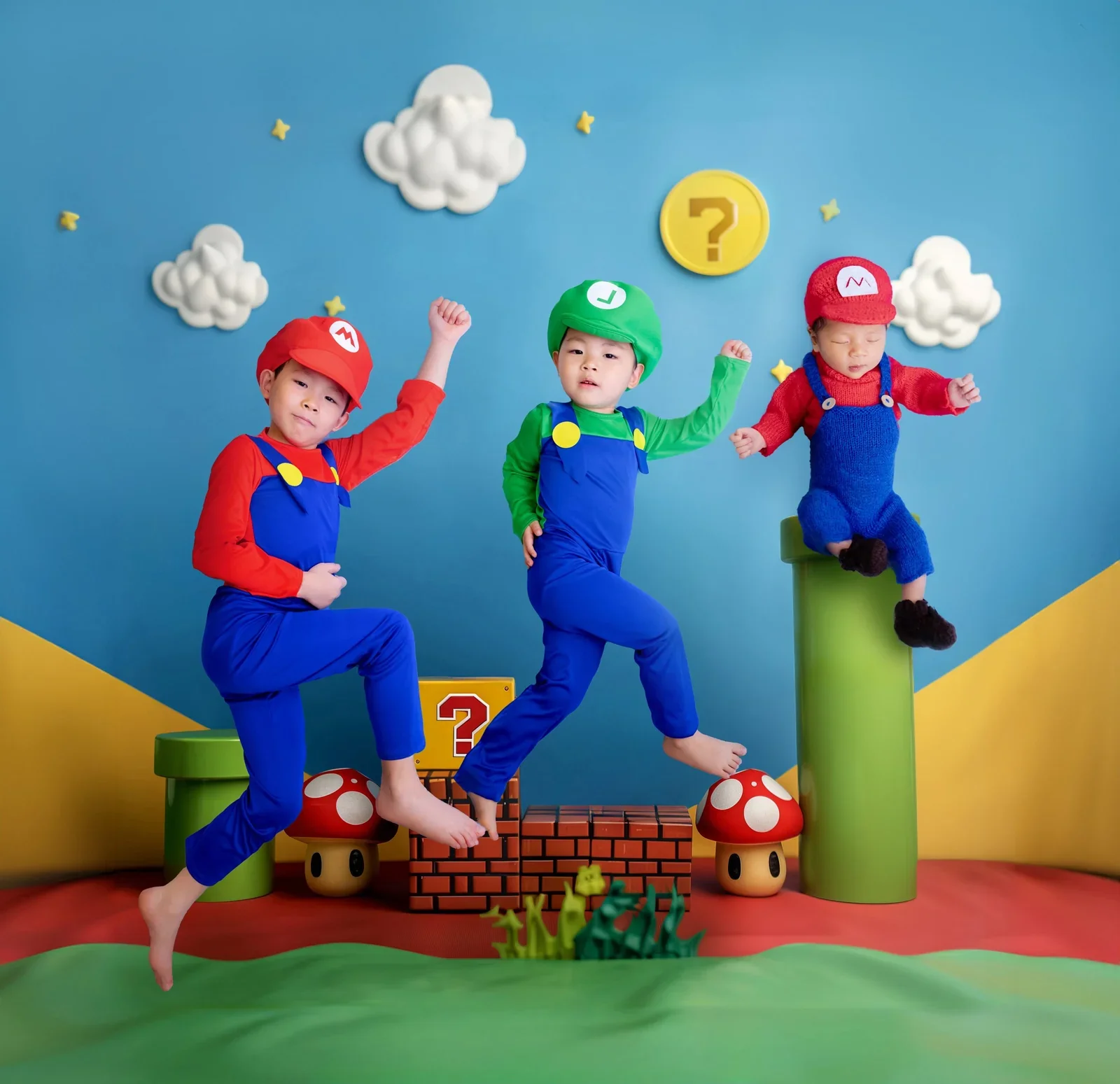 Three children in Mario and Luigi-inspired outfits within a colourful digitally composed game scene