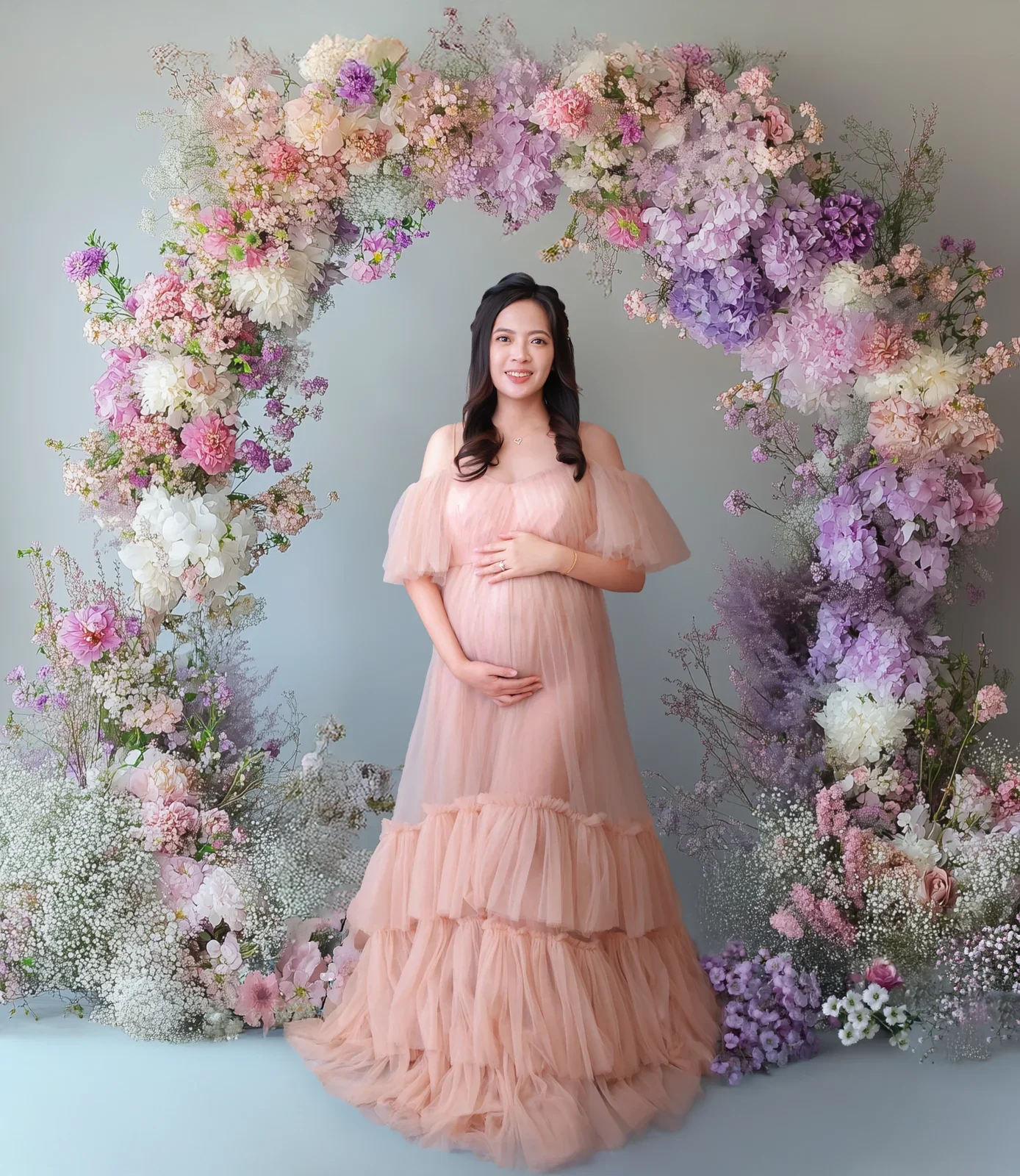 Maternity portrait in a pink gown framed by digitally added flowers