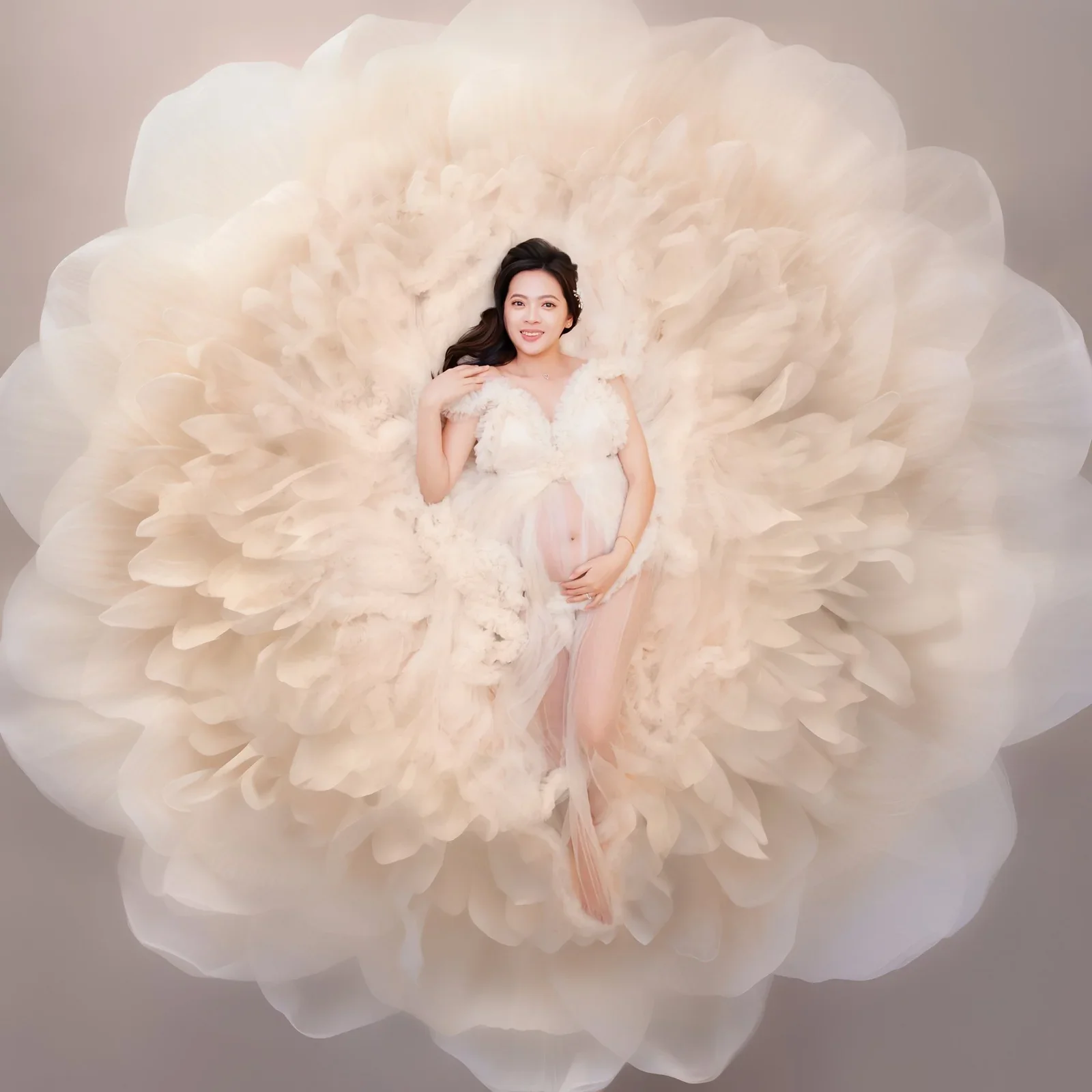 Maternity portrait in a flowing cream gown within a soft floral digital composition