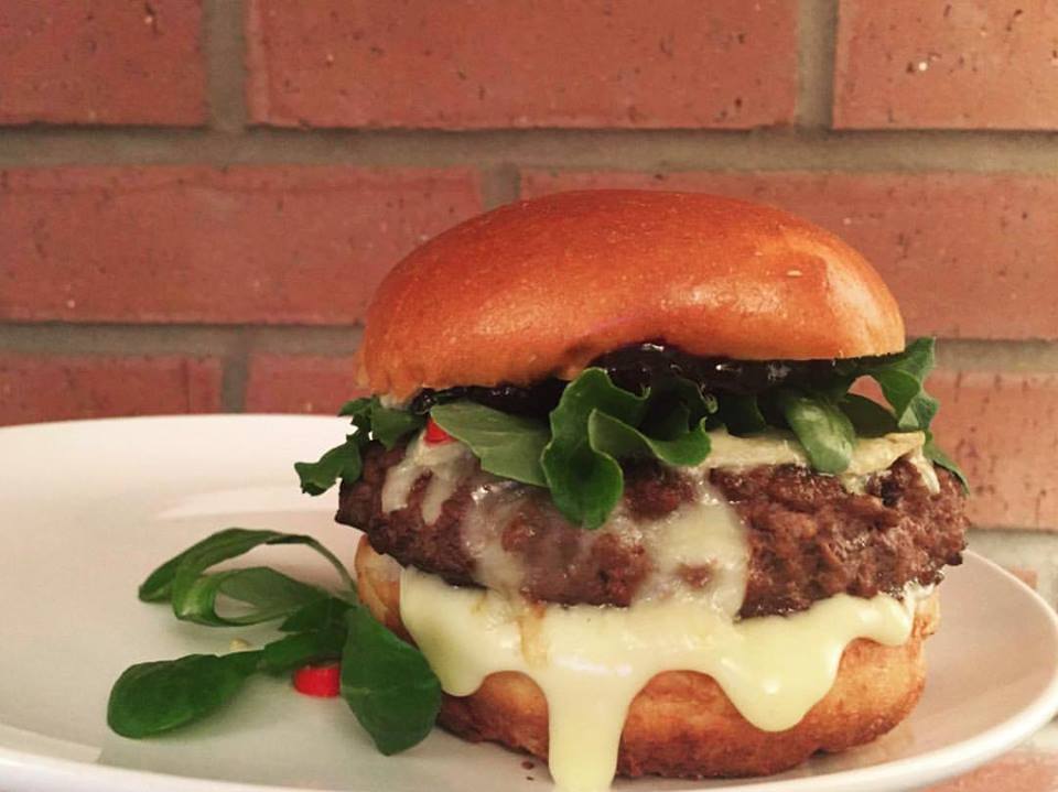 Bison burger with saskatoon berry jam,brie, arugula,pickled chilis and aoili on brioche.jpg