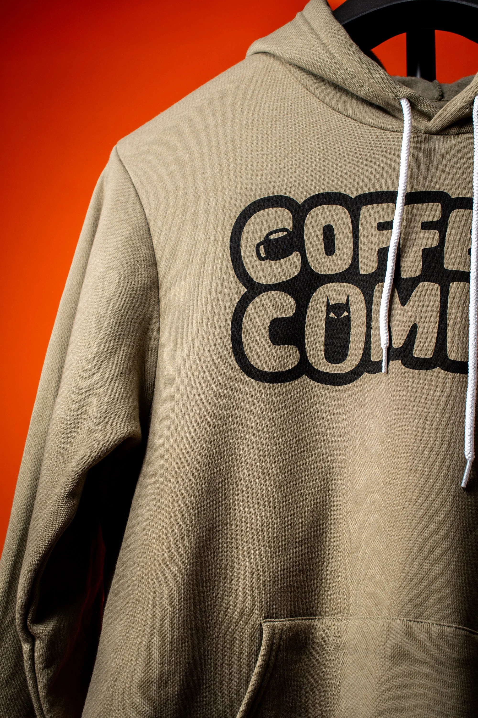 Close up of handprinted Coffee & Comics heather olive hoodie with black print, cozy cotton pullover for comic book and coffee lovers
