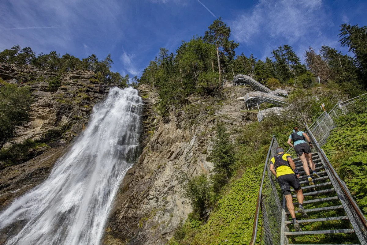 Zwei Läufer auf der freischwebenden Treppe am Stuibenfall bei Umhausen im Ötztal.