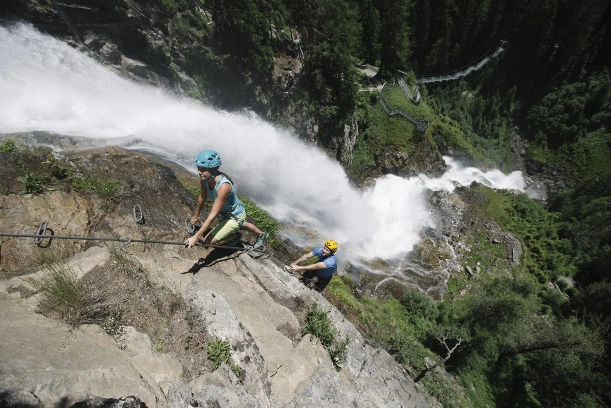 Zwei Kletterer am Stuibenfall-Klettersteig bei Umhausen im Ötztal, im Hintergrund der Wasserfall.