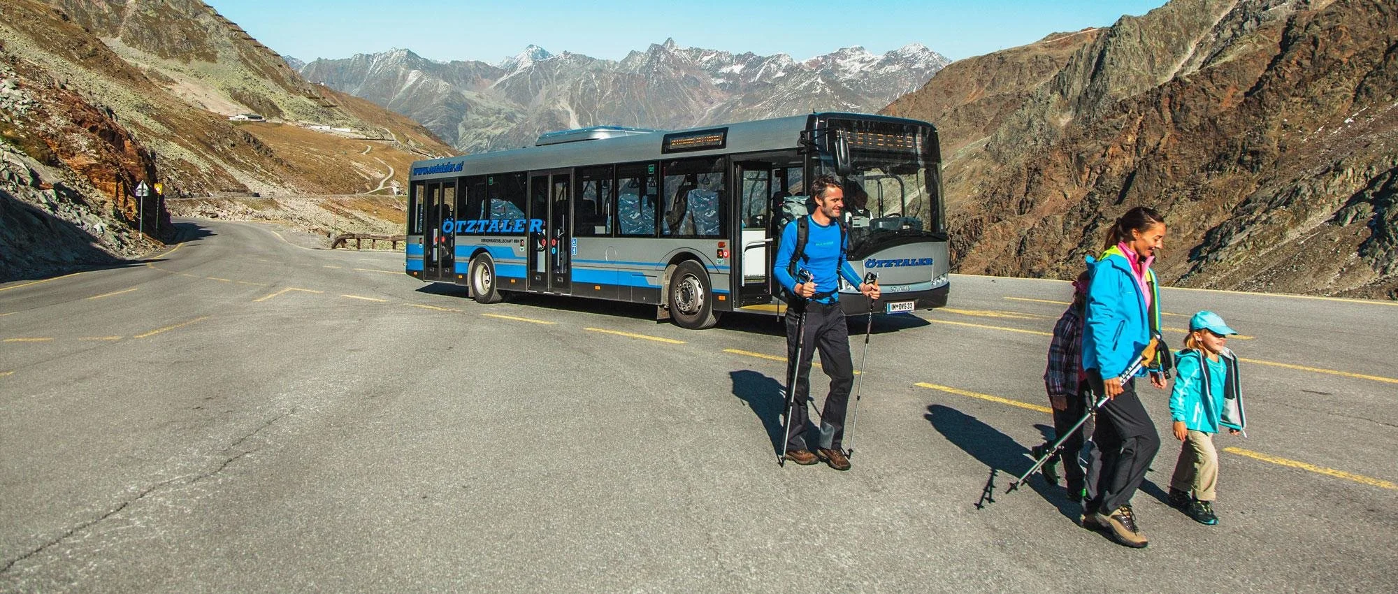 Familie steigt vor einem Linienbus der Ötztaler Verkehrsbetriebe auf der Straße zum Rettenbachferner aus.