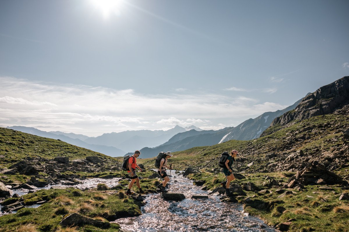 Wanderer überqueren einen Bach auf dem Weg zur Erlanger Hütte in den Ötztaler Alpen.