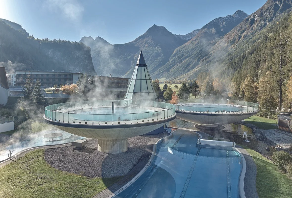 Außenaufnahme des Aqua Dome in Längenfeld im Sommer mit Thermenanlage und Bergkulisse im Ötztal.