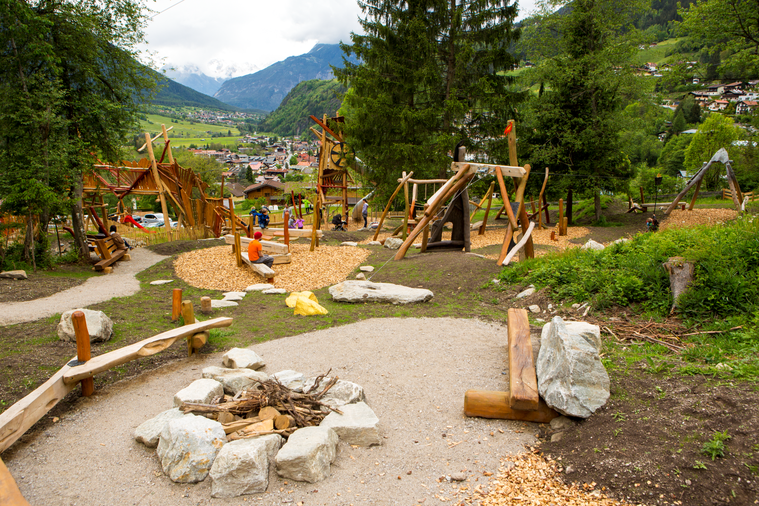 Kinder spielen im WIDI Kids Park in Oetz im Ötztal auf einem Holzparcours.