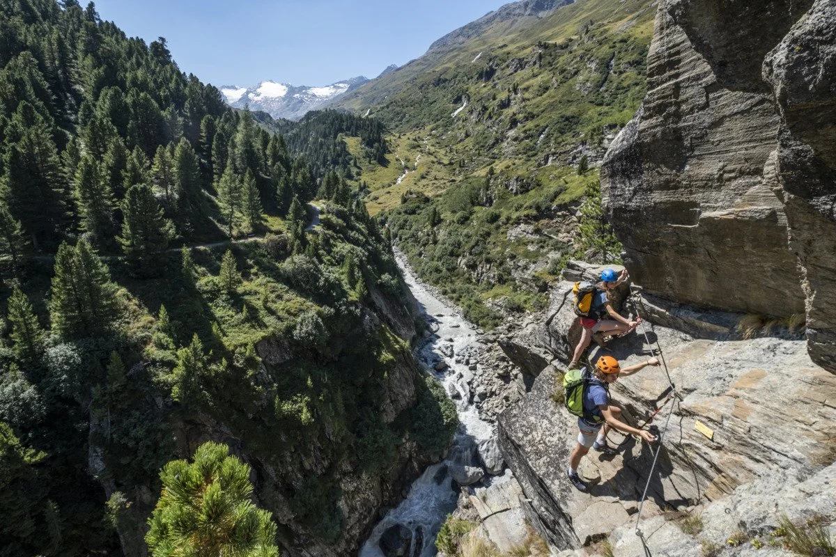 Zwei Kletterer im Klettersteig Zirbenwald in Obergurgl mit Blick ins Gurgltal und auf die Ötztaler Ache.