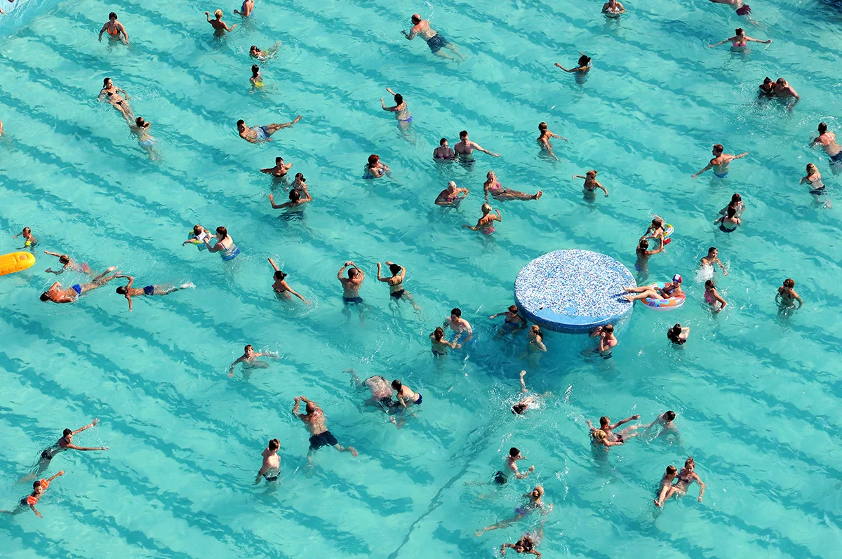  People swim and play in the water the town's outdoor swimming pool. Leisure area located in the very center of Minsk, and along with shashlyk, sun loungers and mineral-rich water, allows to enjoy the atmosphere of classic Soviet sanatorium for a day