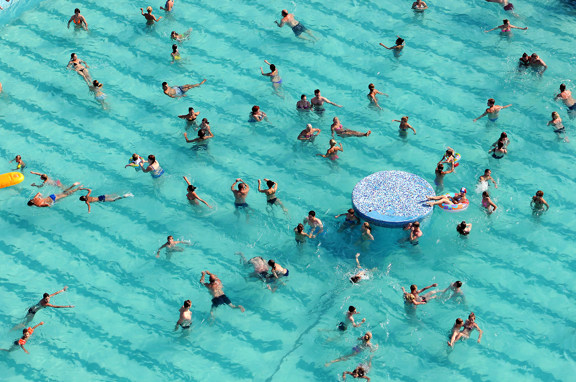  People swim and play in the water the town's outdoor swimming pool. Leisure area located in the very center of Minsk, and along with shashlyk, sun loungers and mineral-rich water, allows to enjoy the atmosphere of classic Soviet sanatorium for a day
