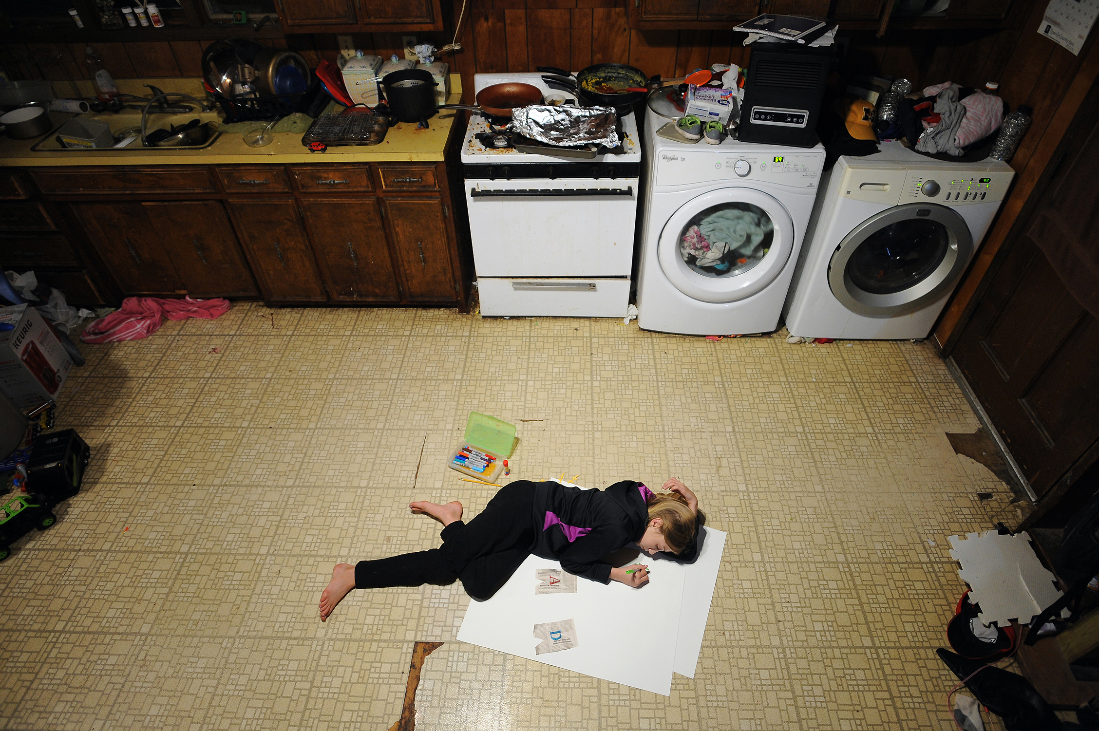 Despite not having a room of her own, Chloe Tool finds a way to make a poster for her dad’s 46th birthday--using the floor of their kitchen as a desk. Dallas Tool (46) lives together with 8 of his 9 kids in a house where he was raised by single mother Mildred Tool (83).
