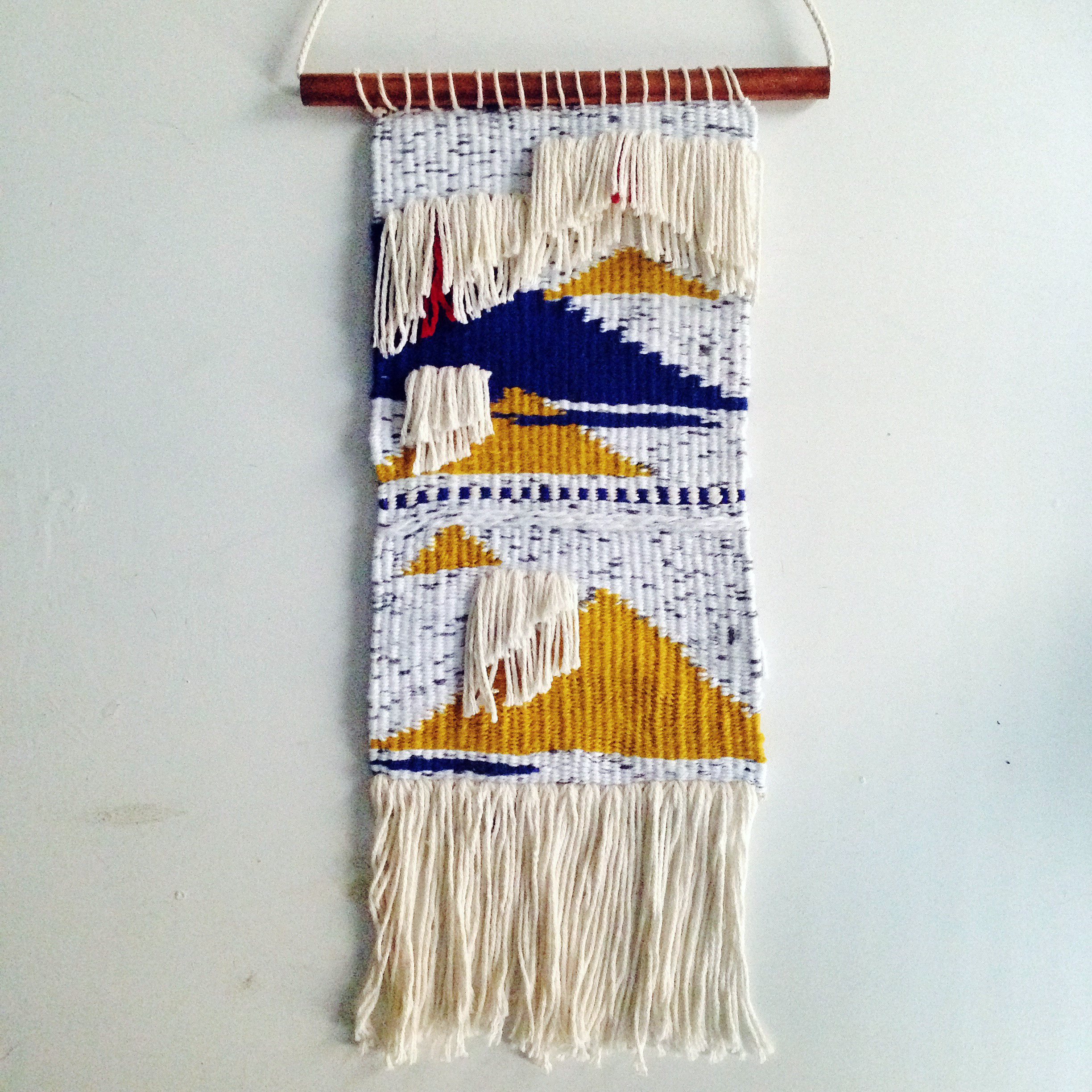The finished weaving hanging from a copper dowel. Kinda wonky, but I'm pretty happy with it.