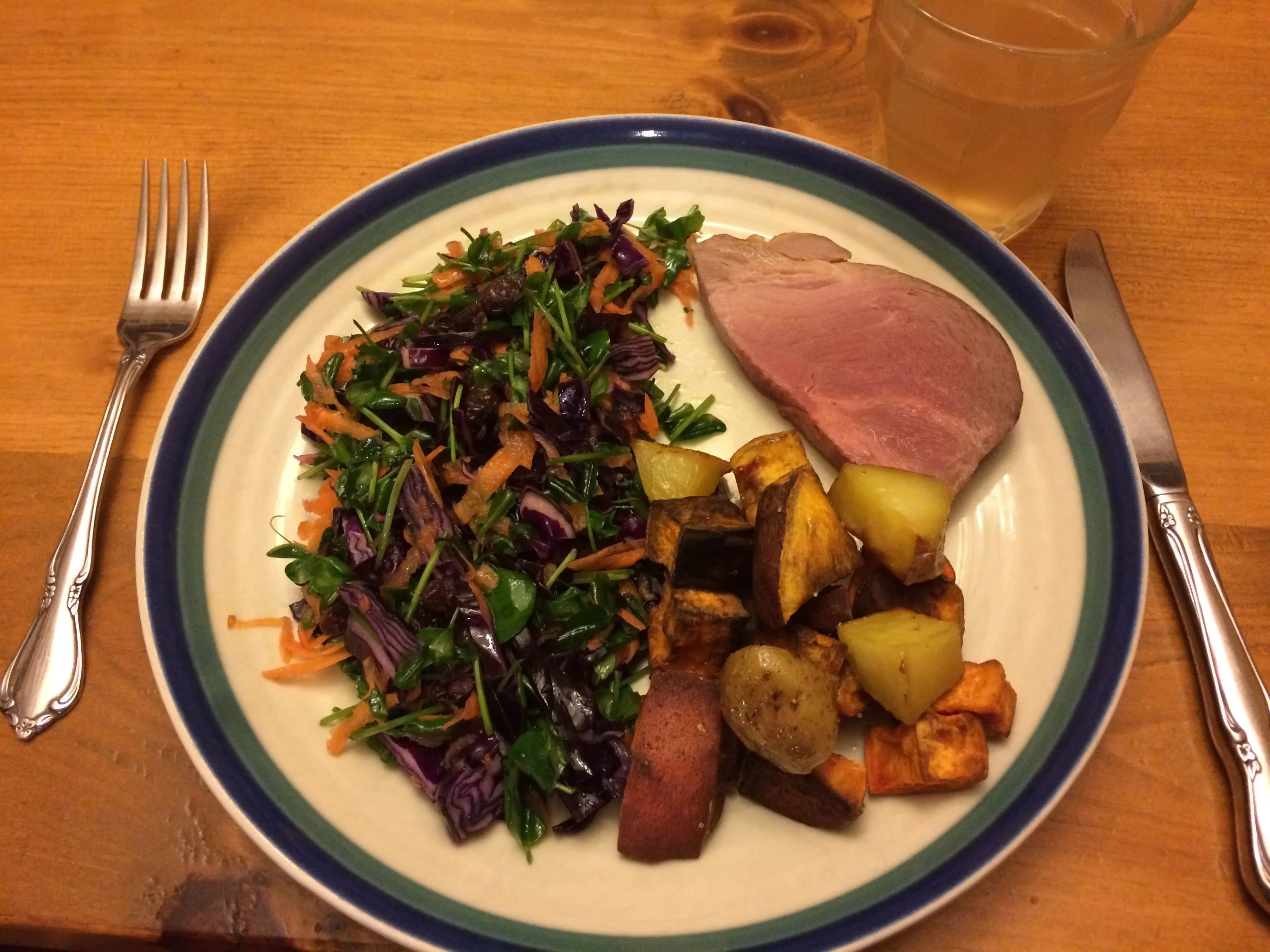 Here’s an example of an AIP or Paleo meal. 1/2 plate filled with Red Cabbage-Carrot-Pea Shoot salad with olive oil, 1/4 plate with a piece of pasture-raised, traditionally cured ham, and a 1/4 plate with a mix of sweet potato and yams roasted in bacon fat.