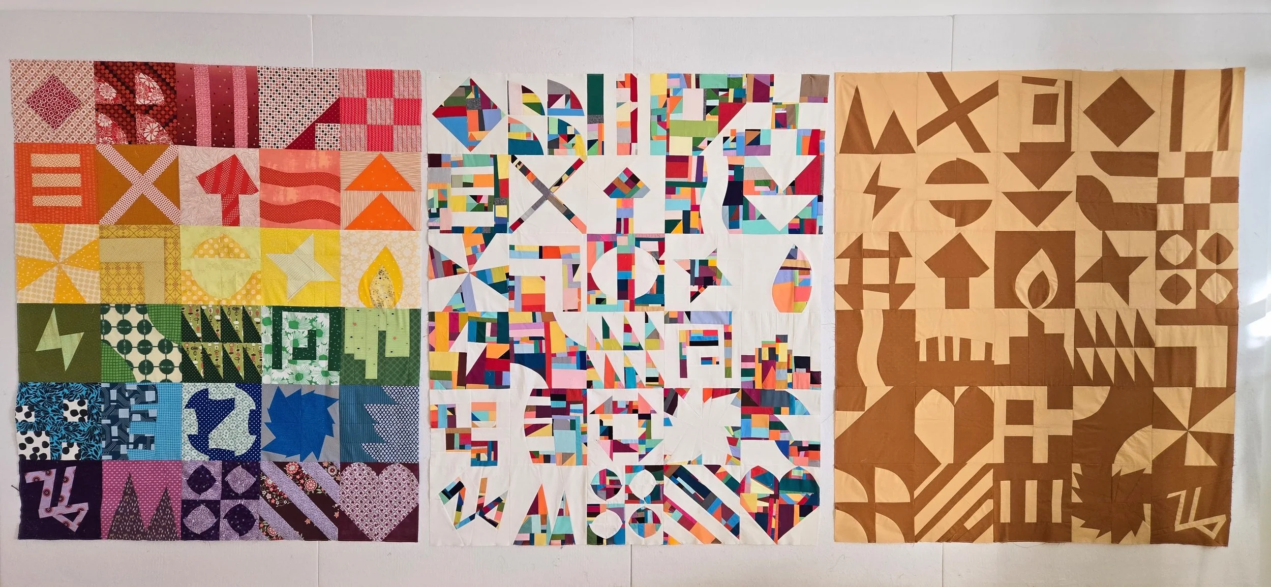 3 quilt tops, all made with the same combination of blocks. 1 in rainbow colours, 1 in multicolour with white, 1 in tan and brown