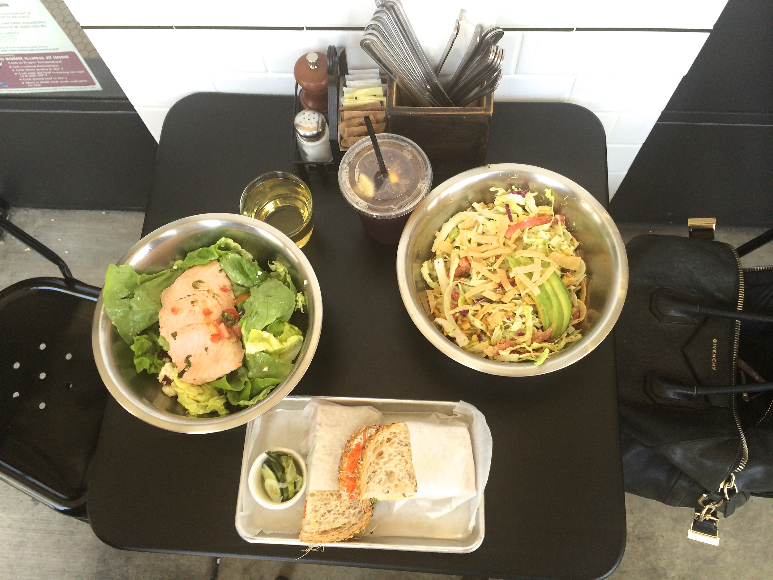 Clockwise from left: Butter L ettuce S alad with salmon, a glass of chardonnay, iced tea, Santa Fe S alad and the Garden S andwich