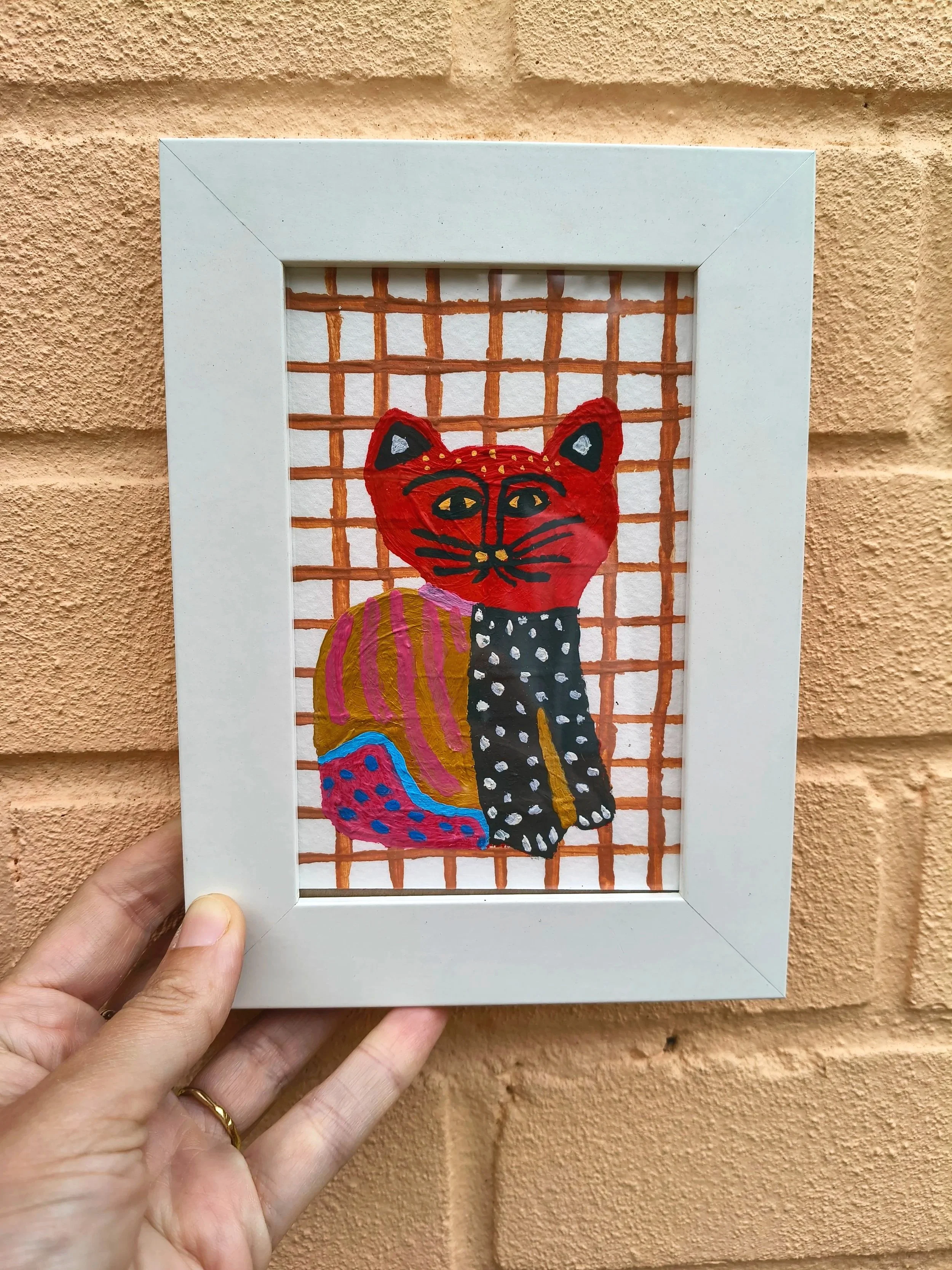 cat painting on pink brick wall