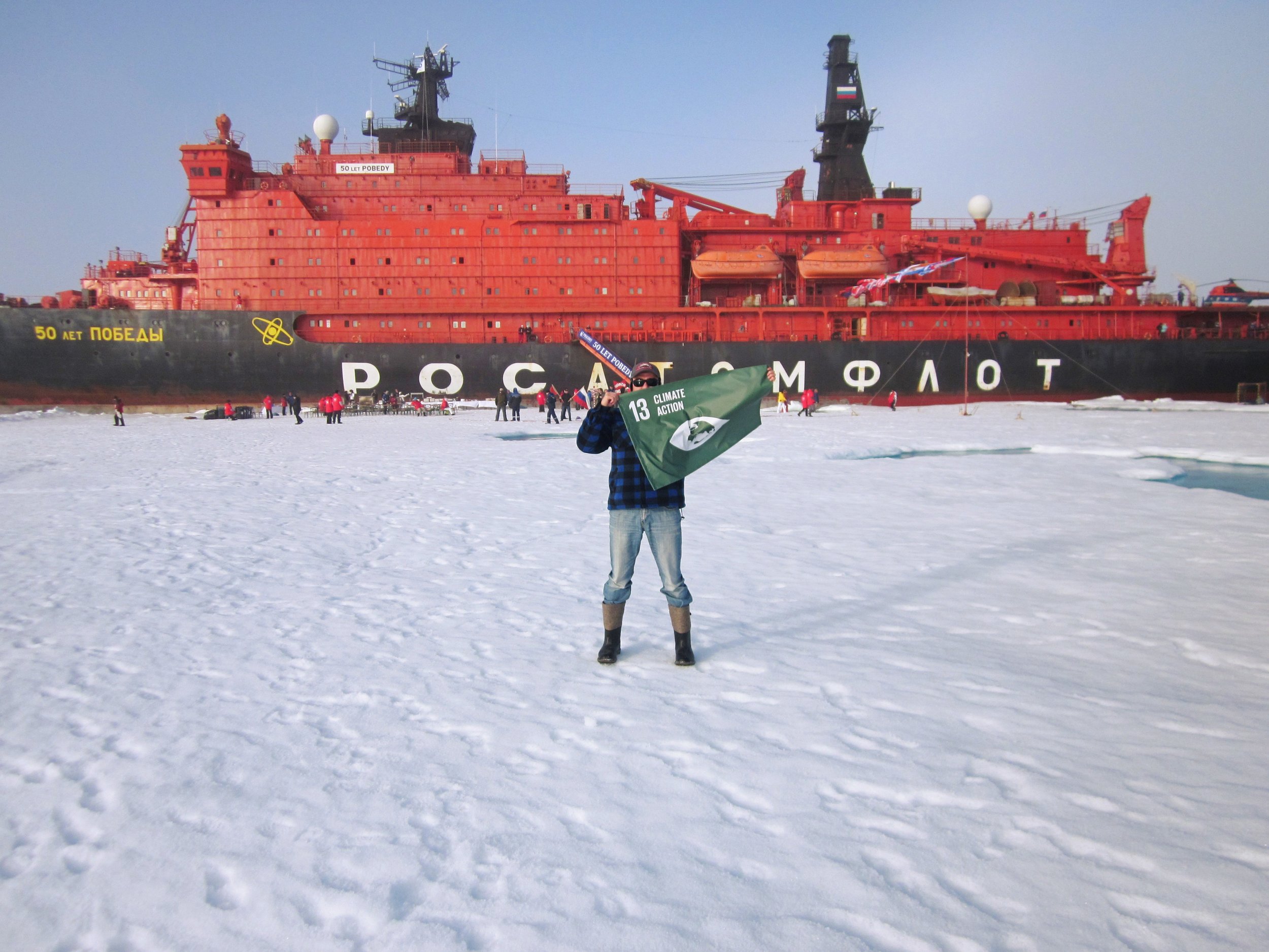 Explorer Inge Solheim raised a flag representing Goal 13, Climate Action, in the community closest to the North Pole, to support the UN Global Goals for Sustainable Development. Image c/o Global Goals media centre .