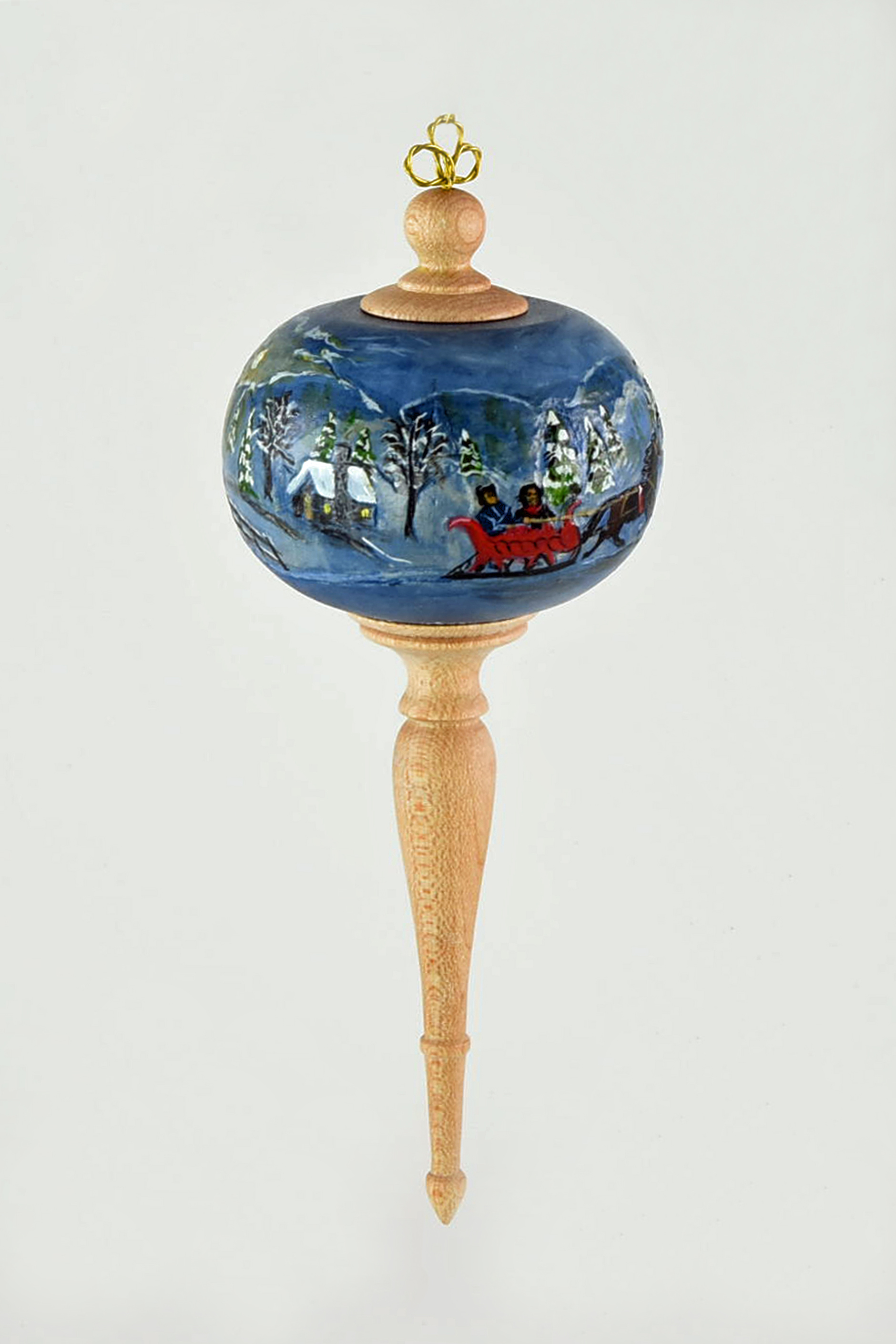 The ball was turned from basswood I wanted to pierce it but had trouble getting an even finish on the inside so I relied on my carving and painting background. I drew a continuous winter scene, relief carved and painted. The finials are made of maple. -Joyce McCullough