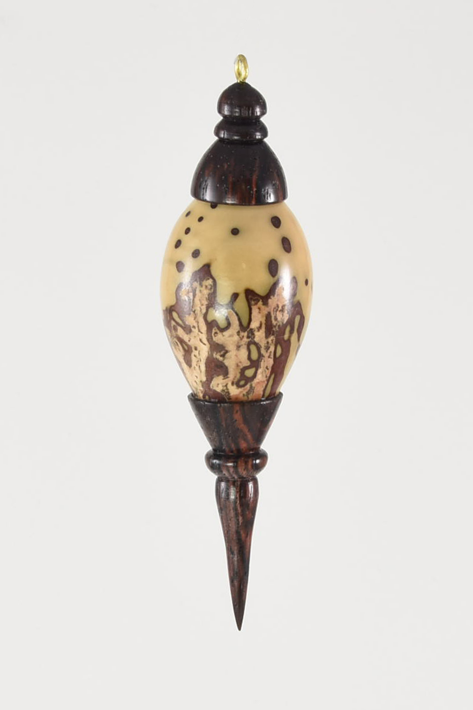 The material I used was Indian rosewood and giant raffia palm nut. I like using different natural materials for any project. I chose the palm nut for its size and natural shape. I figured I'd put the nut back on the tree, even though it isn't the type of tree it came from. -Litton Frank