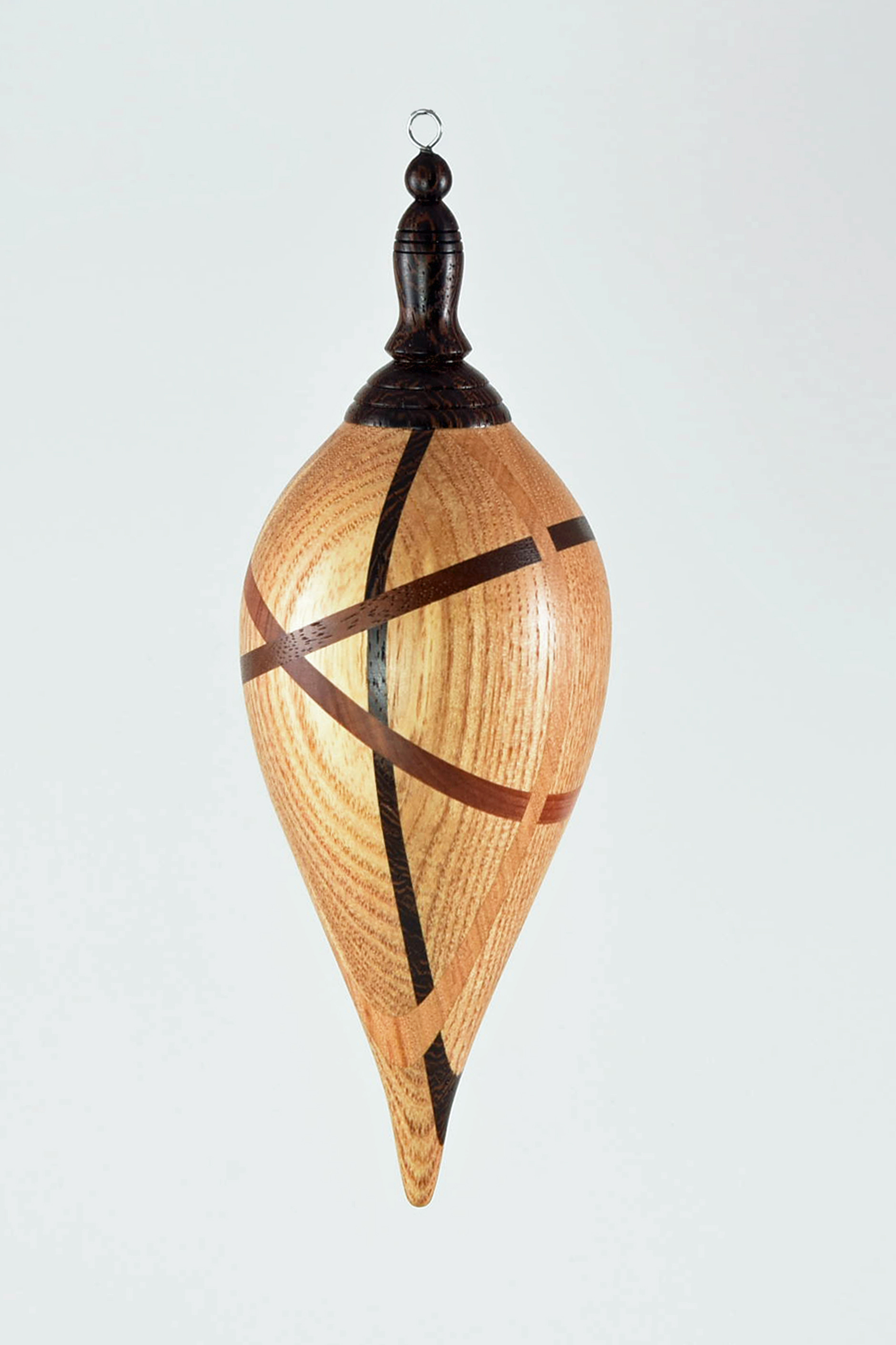 For the ornament, I wanted to do something different, but still have a traditional ornament shape. So I decided to do a random segmented hollow ornament. The main wood is ash with the smaller pieces of wenge, walnut, cedar & cherry. -Mike Conner