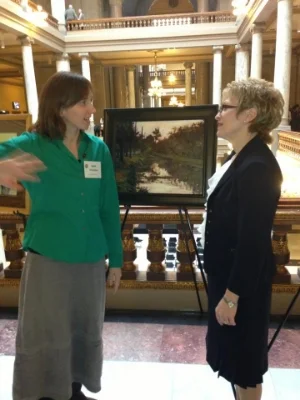 Hirschten speaking with Lt. Governor Sue Ellsperman upon being honored for her painting "6pm on the Canal" at the Indiana State Capitol in 2013.