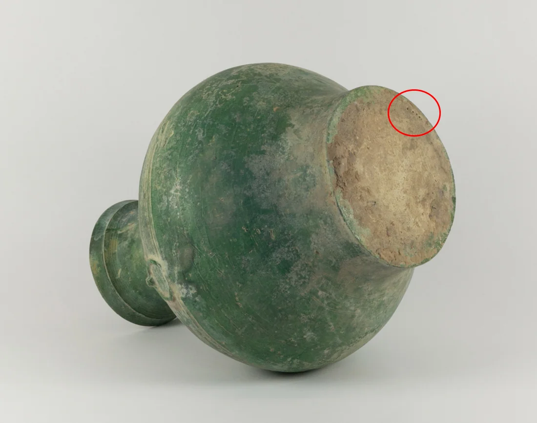 Lot 97: Green-Glazed Han Dynasty Pottery Hu, c. 206 BC-220 AD. Note the small drill holes from where the TL test sample was obtained.