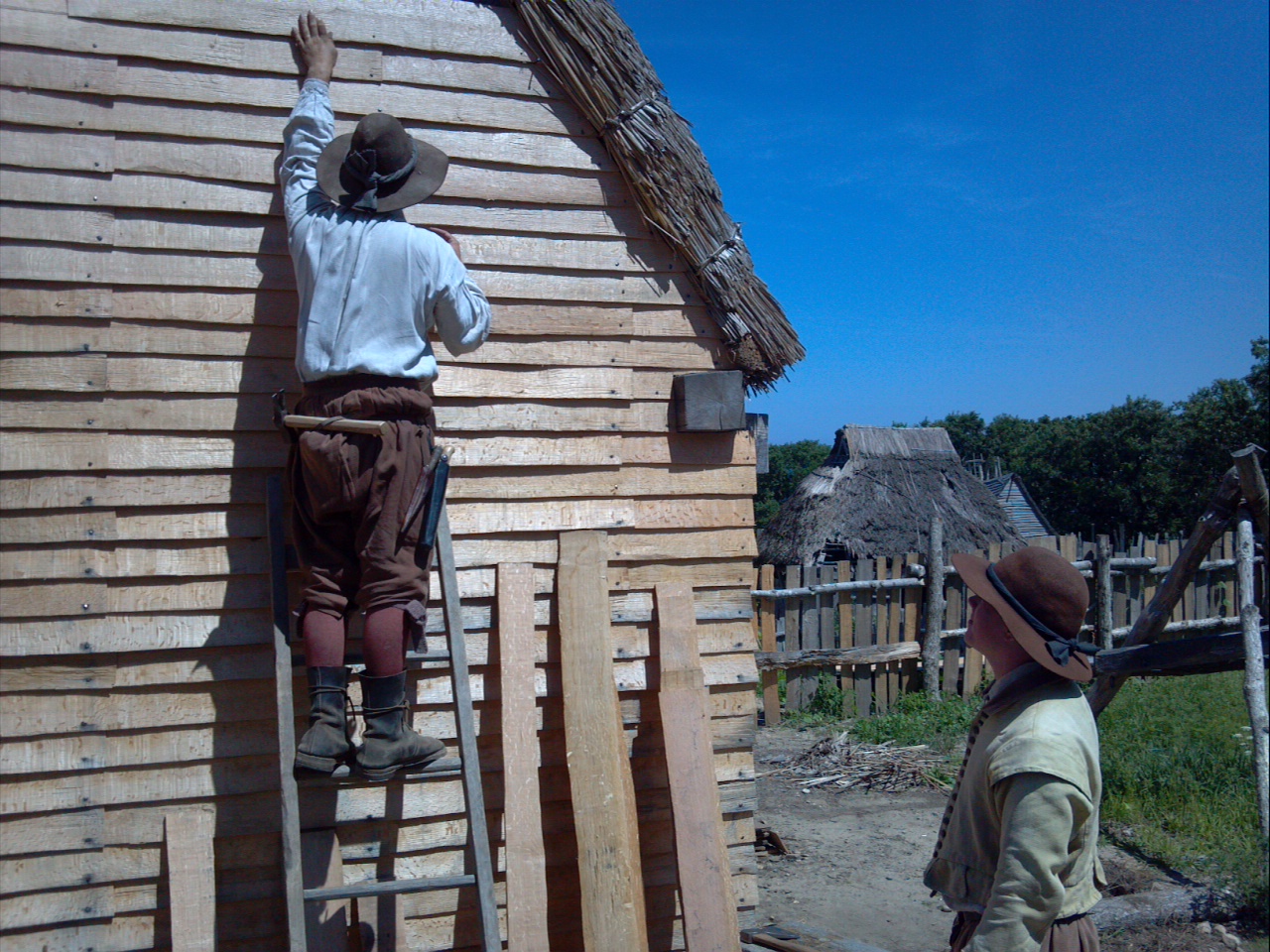 English pilgrims build a house - in warm weather. (Taken at the Plimoth Plantation, August 2014.)