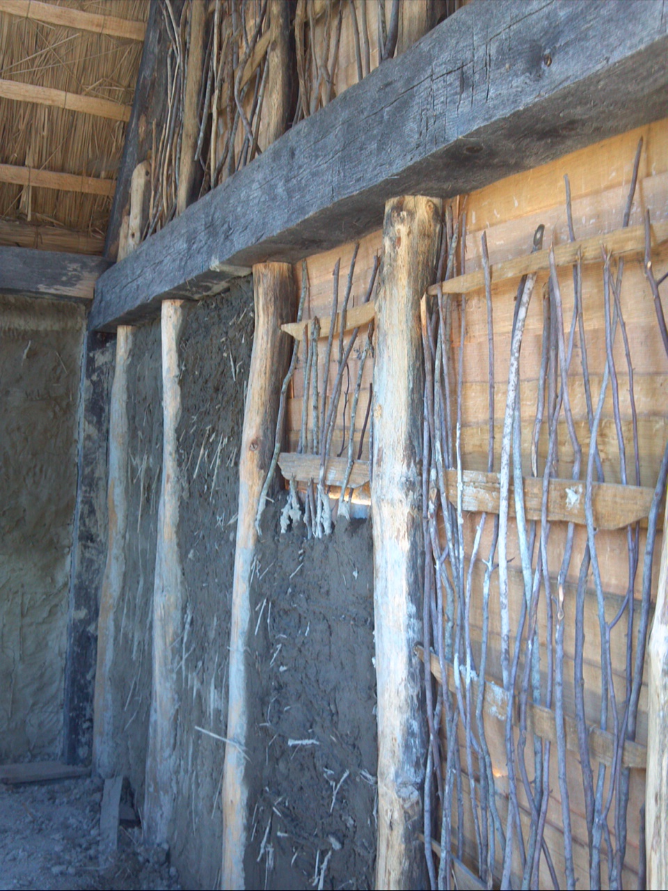 Inside wall, partially completed. Mud is used to seal and insulate the walls. (Taken at Plimoth Plantation, August 2014.) 