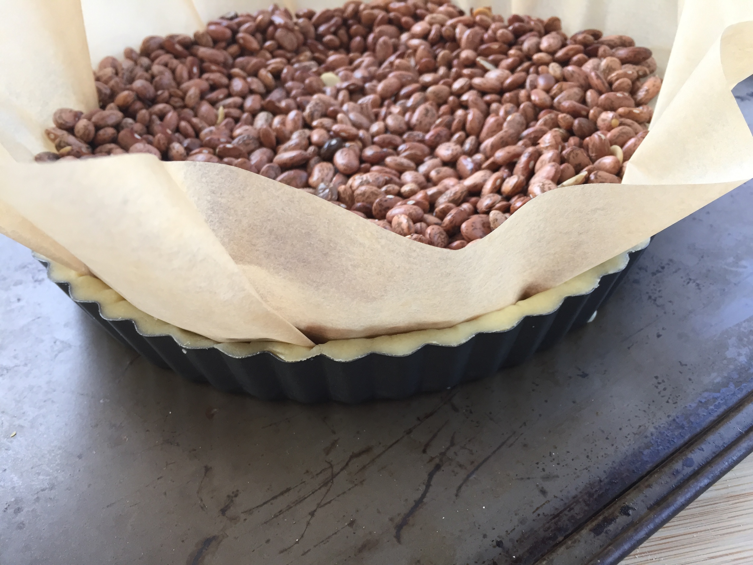 Lined with parchment and filled with beans for pre-baking.