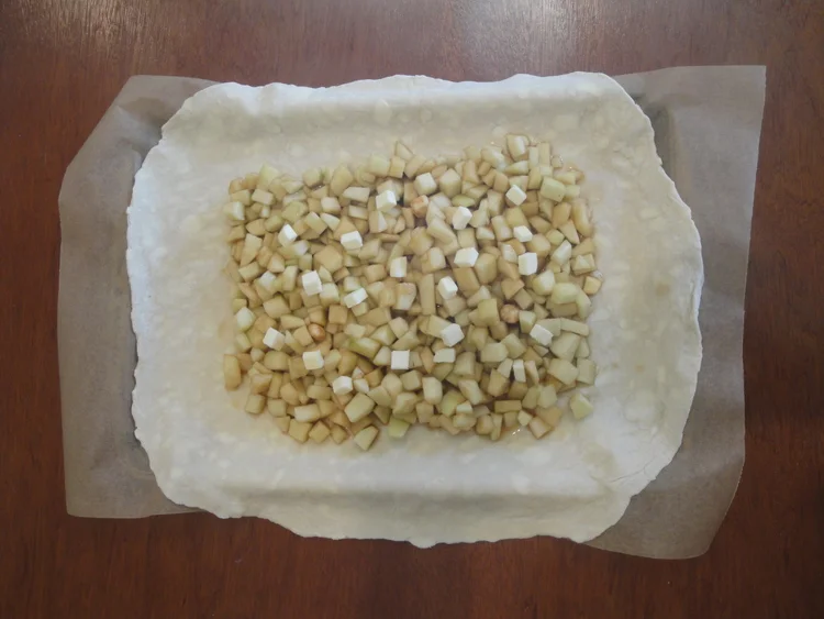 Apples, dotted with butter, in the center of the pastry.