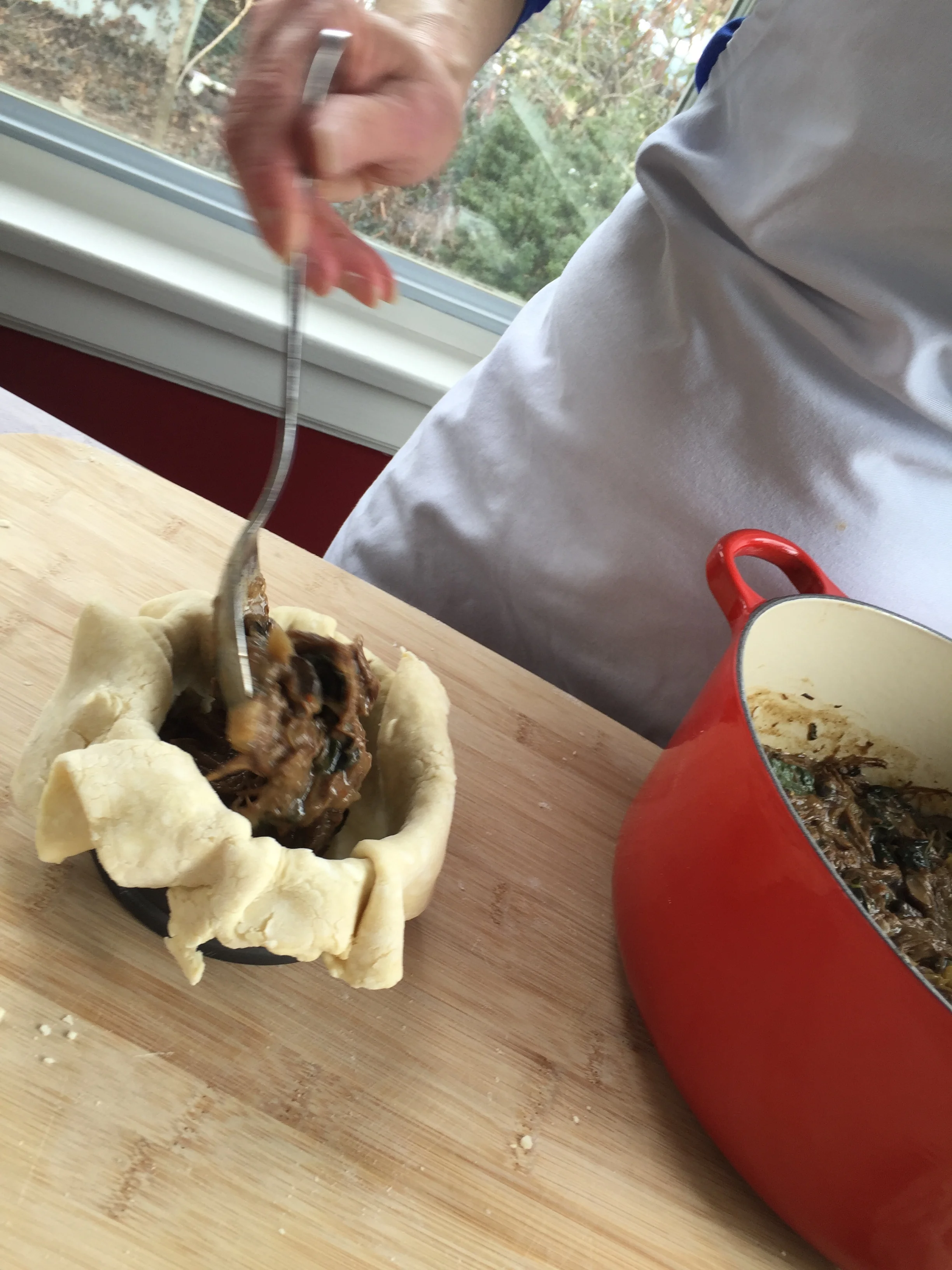 Spooning the meat filling into a pot pie. See more detailed step-by-step photos in People Like Pie .