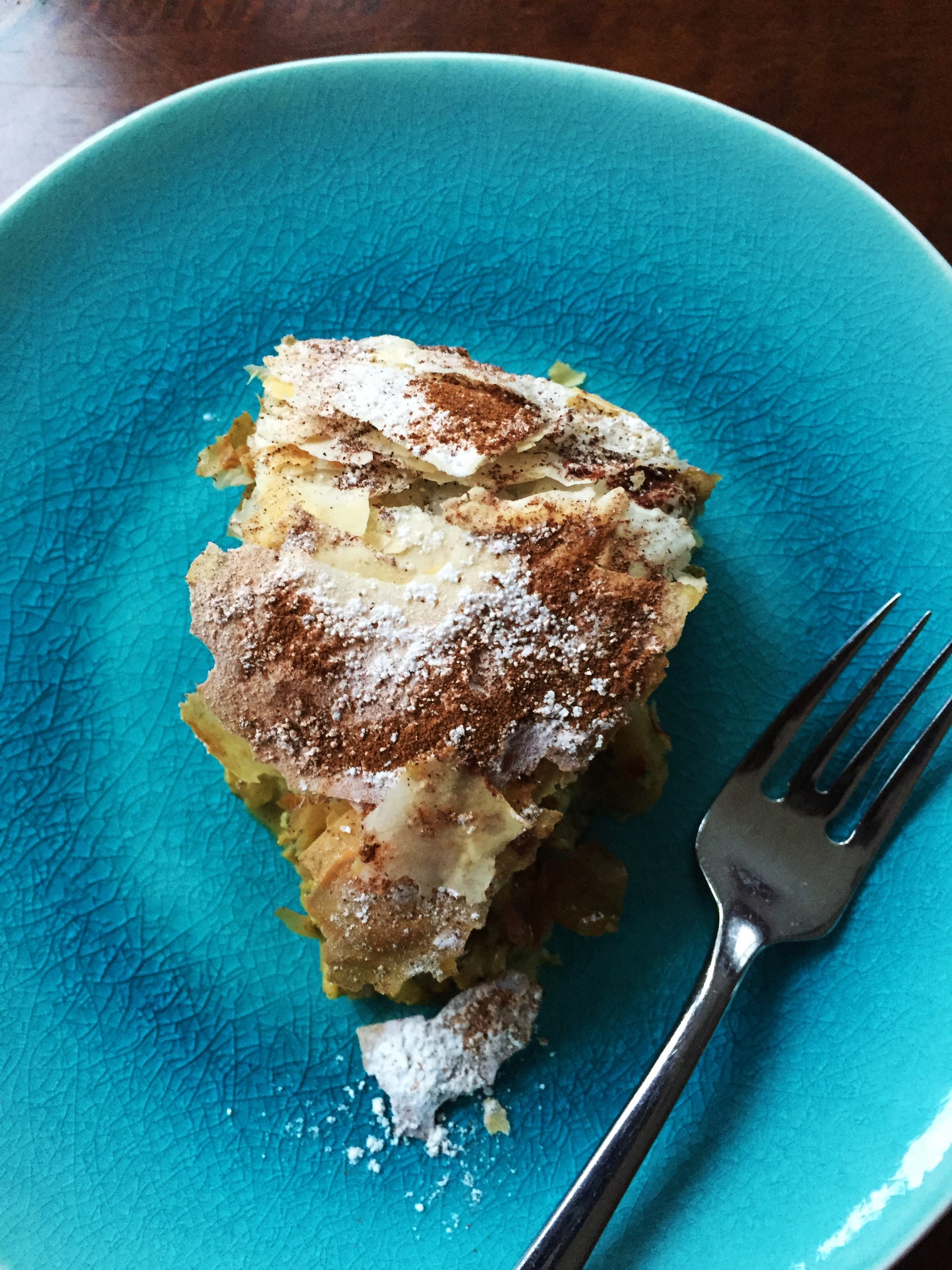 A slice of Moroccan B'Stilla Pie made in the Adventure Kitchen. This Moroccan poultry pie combines sweet and savory flavors in one really amazing dish. In Morocco, It's traditionally served as a starter at festive occasions such as weddings. You can serve it as an entree, or a really fancy side or starter.